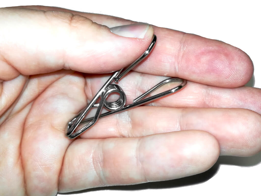 Metall-Futterklammer auf einer Hand als Größenvergleich